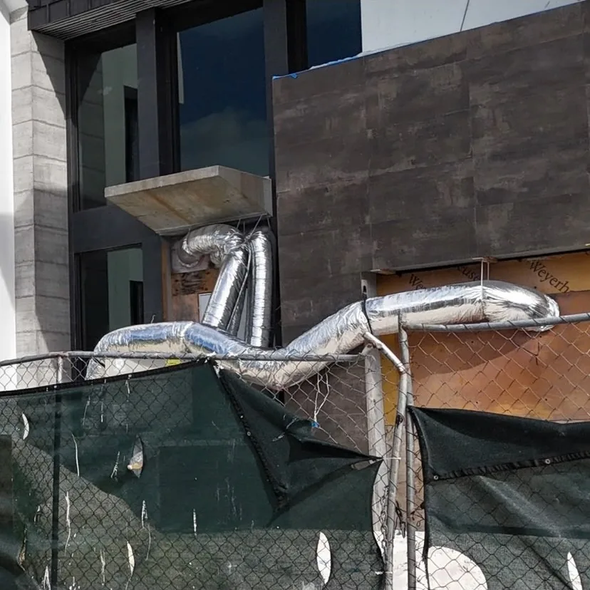 Insulated pipe and duct run on a commercial building exterior
