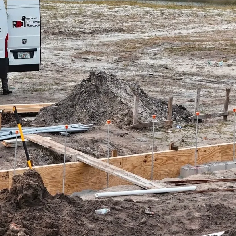 Staked out underground plumbing on a new construction foundation